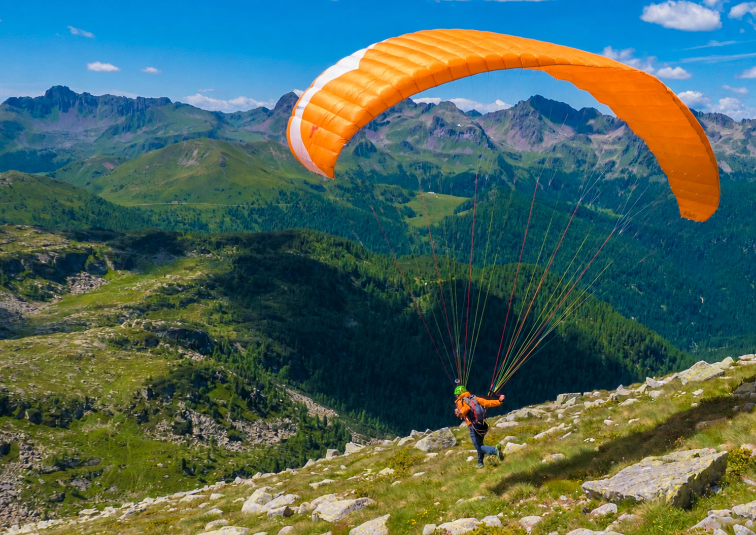Décollage en parapente au-dessus d’une vallée alpine